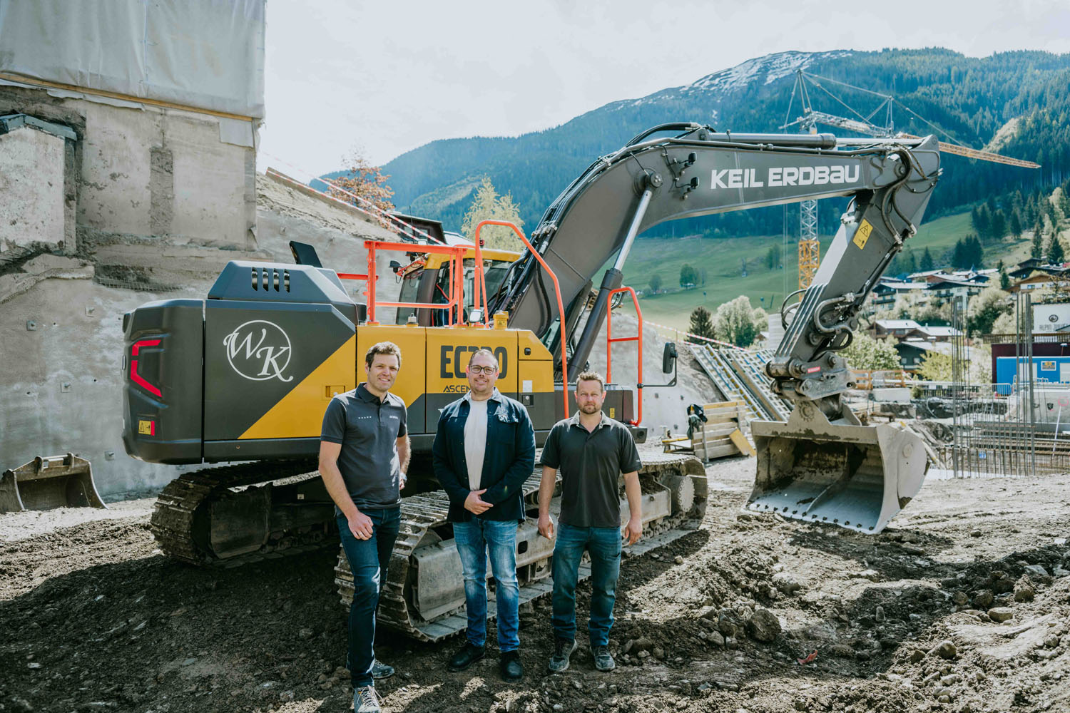 Bagger Keil Erdbau mit drei Männern vor Bergkulisse in Österreich